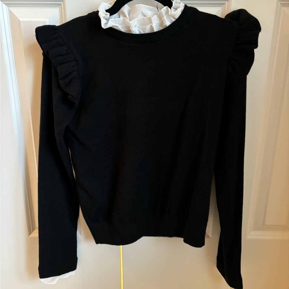 Black, puff sleeved white ruffled collared shirt.